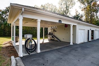 The front of a garage with a gas pump in the driveway